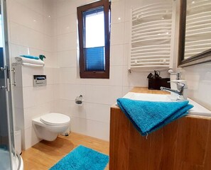 Enjoy a clean and minimalist bathroom with a toilet, sink, and window.