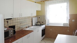 A compact kitchen with white cabinets, a gas stove, a microwave, and a coffee maker. - Holiday Home in Kolczewo by the Lake (gmina Wolin)