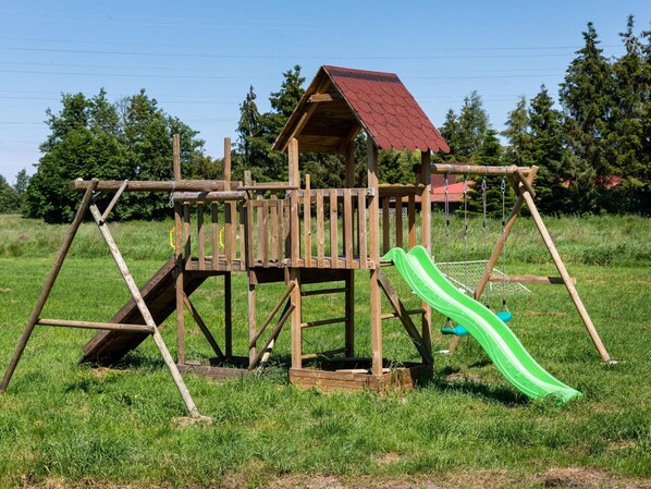 A wooden playground structure with a slide and climbing elements. - Brick Cottage Near Baltic Sea and Windmill (gmina Karnice)