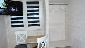 A small, enclosed room with a window, two chairs, a table, and a coat rack. - Holiday House in Dziwnowek Near Sea and Lake (Kamien Pomorski)