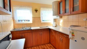 Une cuisine avec des meubles de rangement en bois, un évier, un four à micro-ondes et un réfrigérateur.