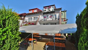 A multi-story building with balconies, outdoor seating, and a covered patio area. - Cozy Holiday Apartment Close to the Beach (Kołobrzeg)