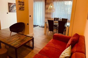 Relax in this inviting living room with a sofa, coffee table, and dining area.