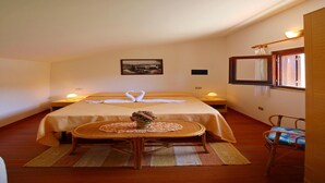 Una habitación de hotel acogedora con una cama individual, una mesita con un florero y una silla.