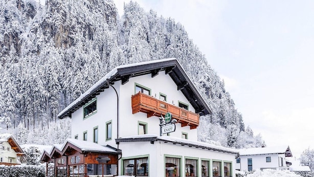 A two-story building with a balcony, surrounded by snow-covered trees. - Penthouse in Strass Near Zillertal Alps (Strass im Zillertal)