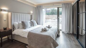 Un dormitorio moderno con una cama grande, una mesita de noche y vistas al exterior.