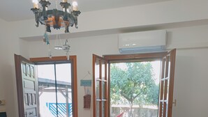 A dining area with a hexagonal tiled floor, a table with a tablecloth, chairs, and a chandelier. - Adriano's beach house (Anzio)