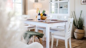 A dining area with a white table, chairs, a lamp, and a fruit bowl. - Ferienhaus mit Sauna in Boiensdorf (Boiensdorf)
