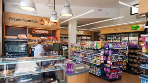 Una sección de panadería con productos horneados y un expositor refrigerado.