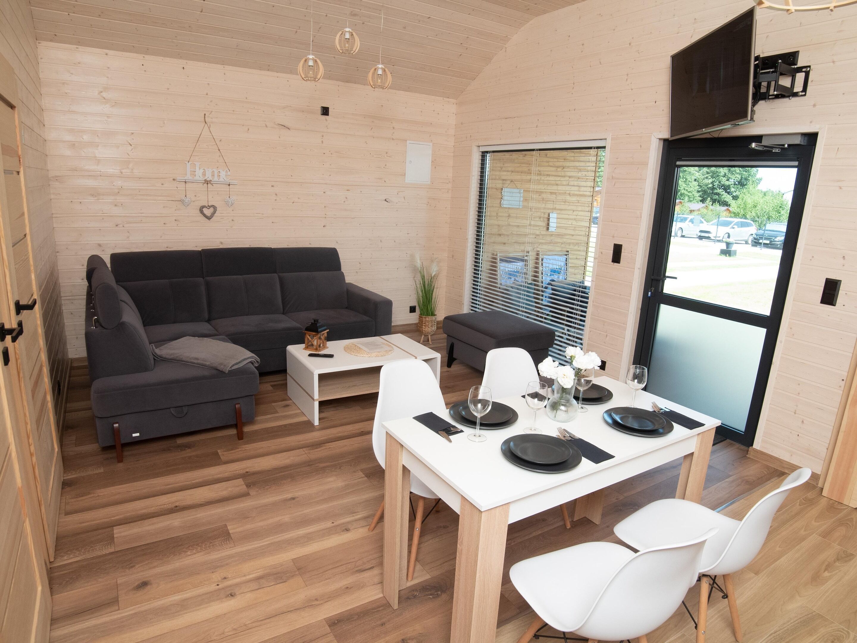 A modern interior with a sofa, dining table, and chairs.