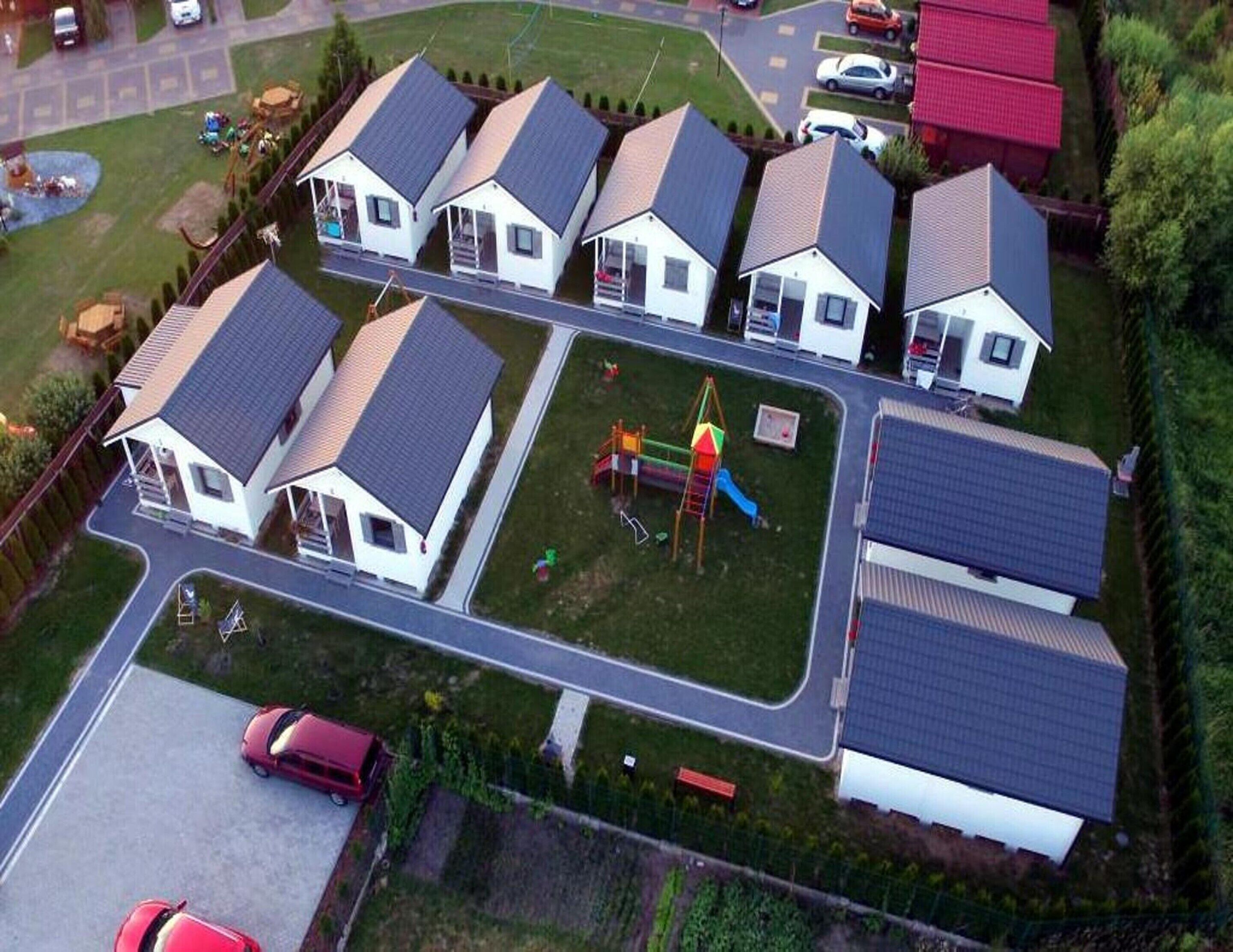 A residential area with multiple houses, a playground, and a parking lot.