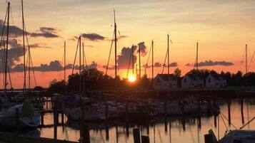 A marina at sunset with multiple boats docked.