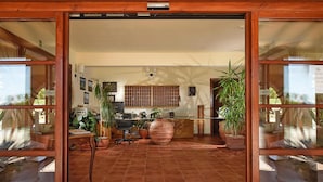 A reception area with a wooden desk, chairs, potted plants, and a tiled floor. - Apartment in Residence Borgo Magliano, in Magliano (Magliano in Toscana)