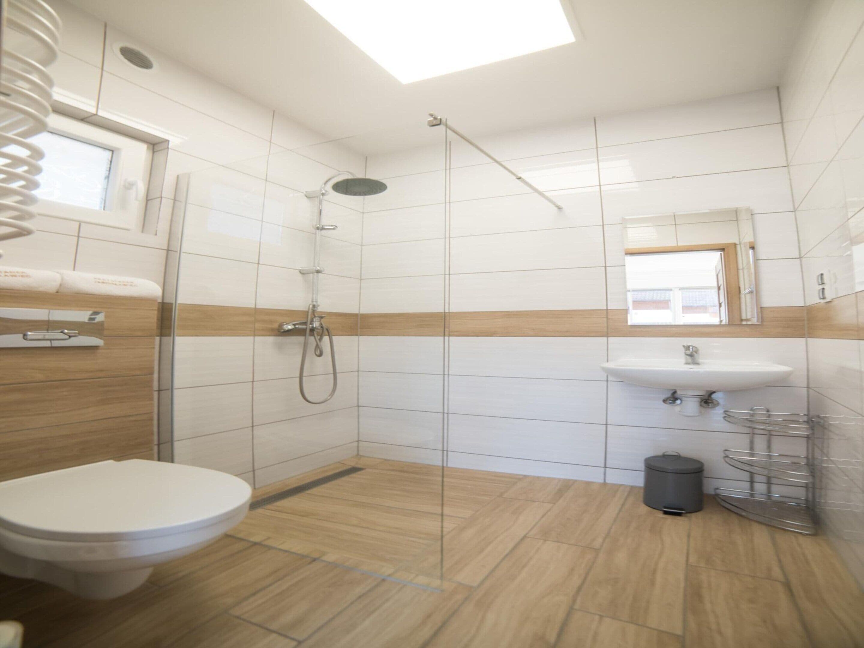 Ein modernes Badezimmer mit Dusche, Toilette und Waschbecken.