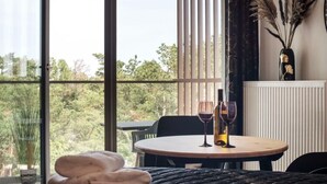 A cozy room with a round table set for two, a vase with dried plants, and a view of greenery outside. - Apartment in Pobierowo Near Beach and SPA (Rewal)