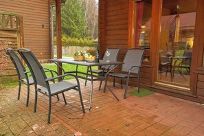 A patio with a table and chairs, a basket of fruit, and a bottle of wine. - Doppelhaushalfte in Hasselfelde (Oberharz am Brocken)