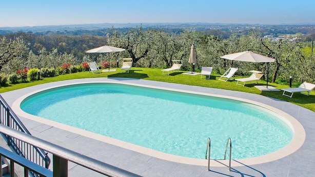 A swimming pool with a view of the countryside, surrounded by lounge chairs and umbrellas. - Beautiful Apartment in Lamporecchio (Lamporecchio)
