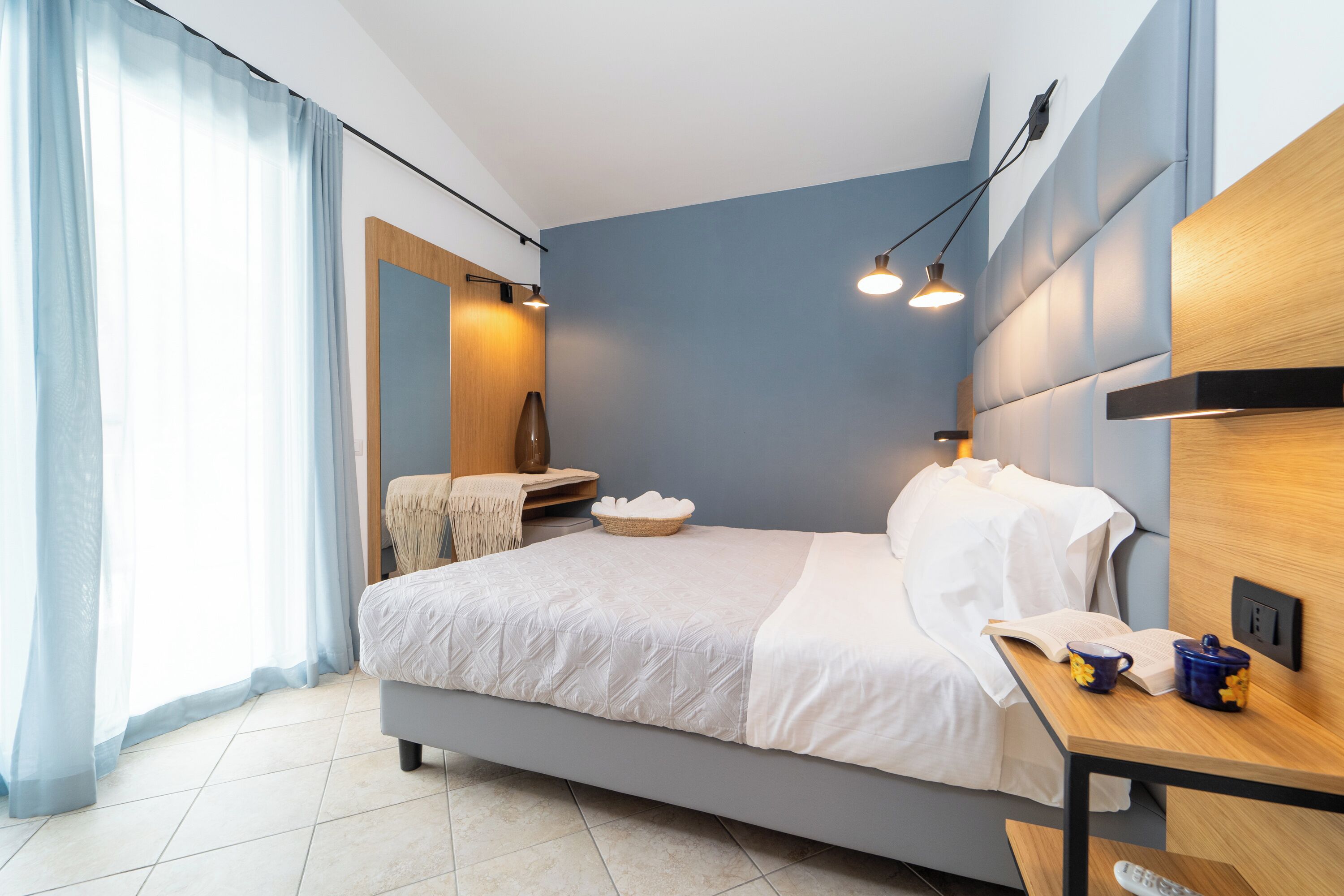 Ein modernes Schlafzimmer mit Bett, Nachttisch und Beistelltisch.