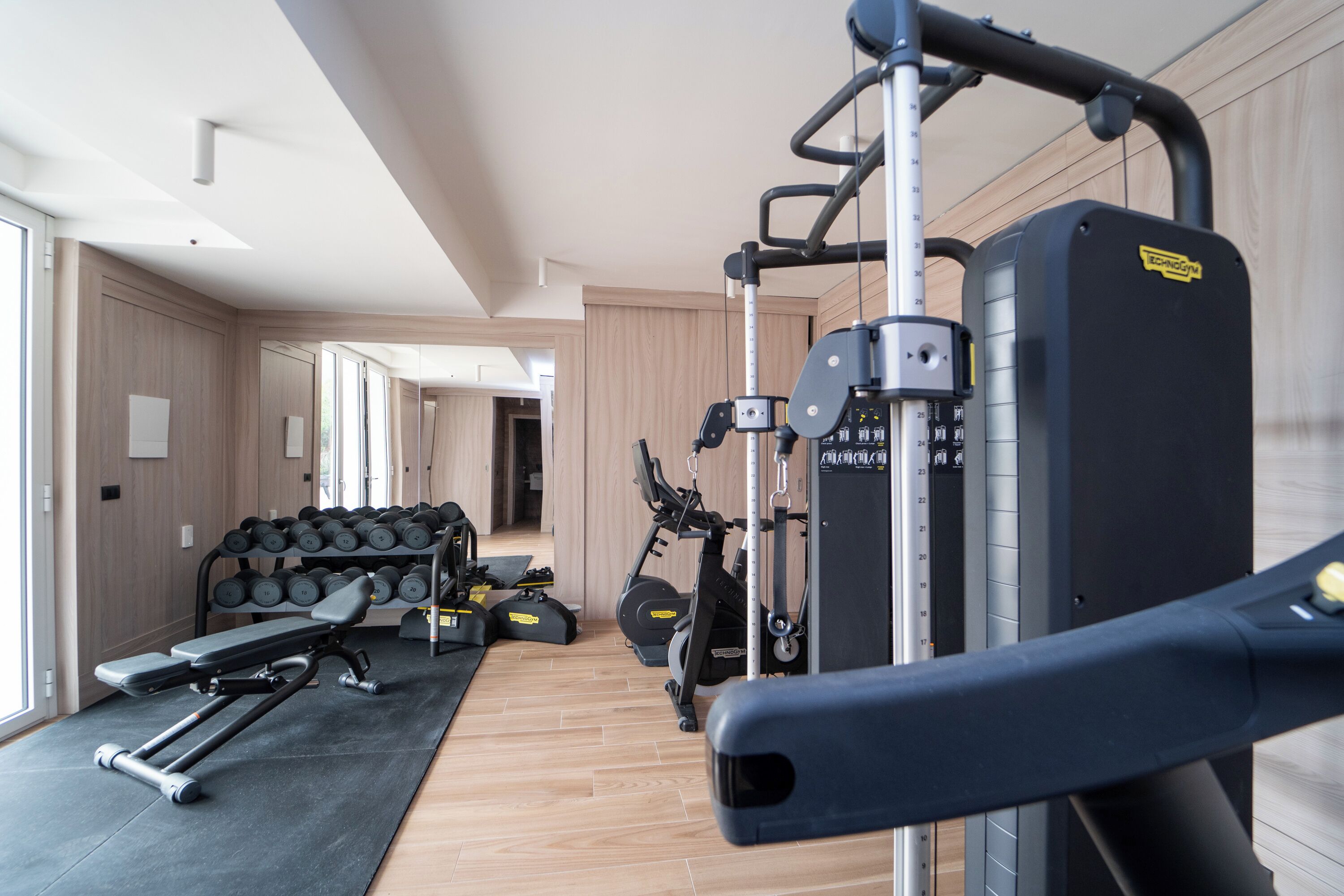 Una palestra moderna con attrezzature per esercizi, rastrelliere per pesi e un tapis roulant.