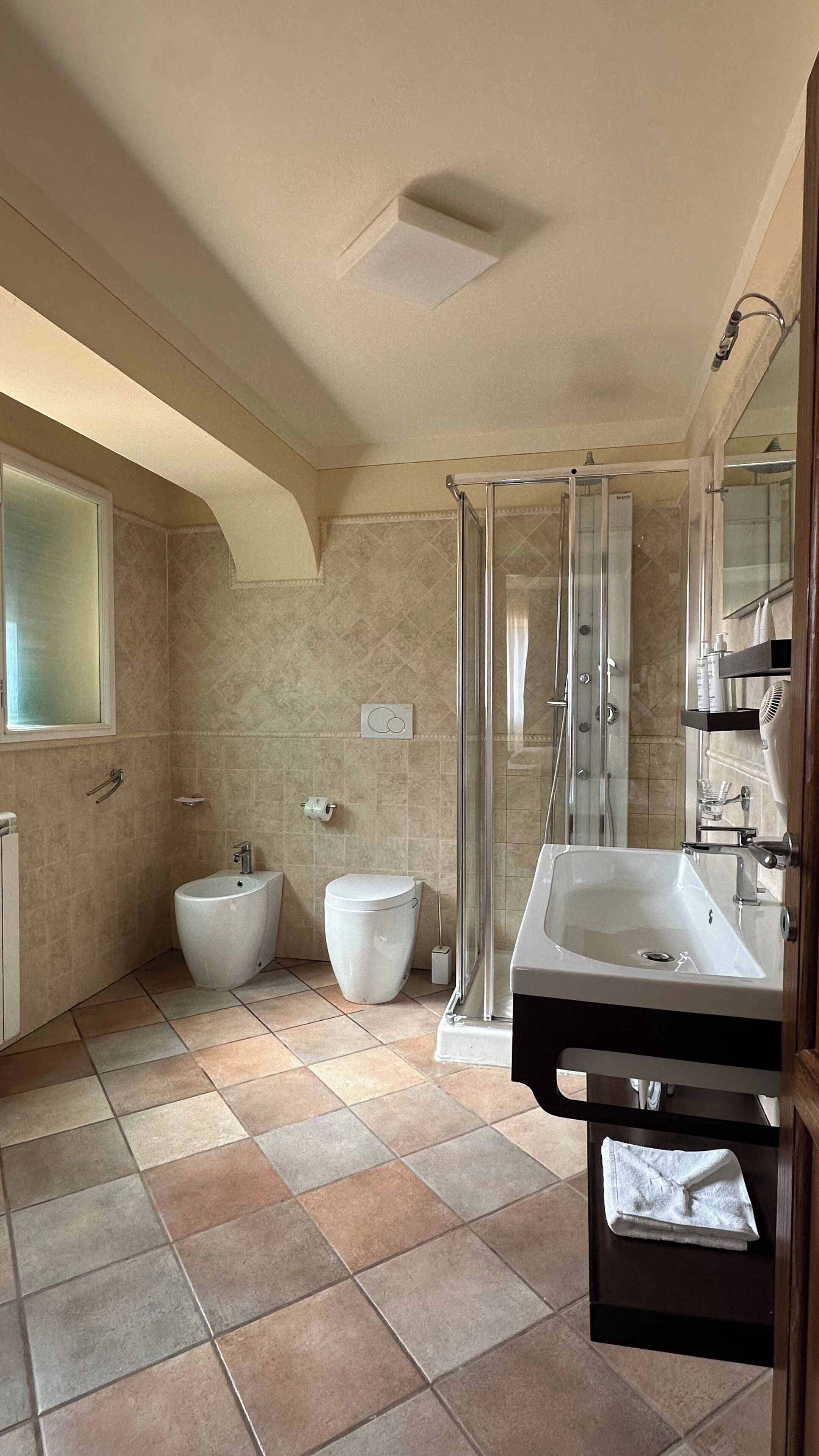 A bathroom with a shower, toilet, and sink.