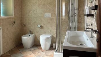 A bathroom with a shower, toilet, and sink.