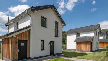 Stylish two-story residence with a minimalist design, featuring a white and dark trim exterior and a slatted facade.