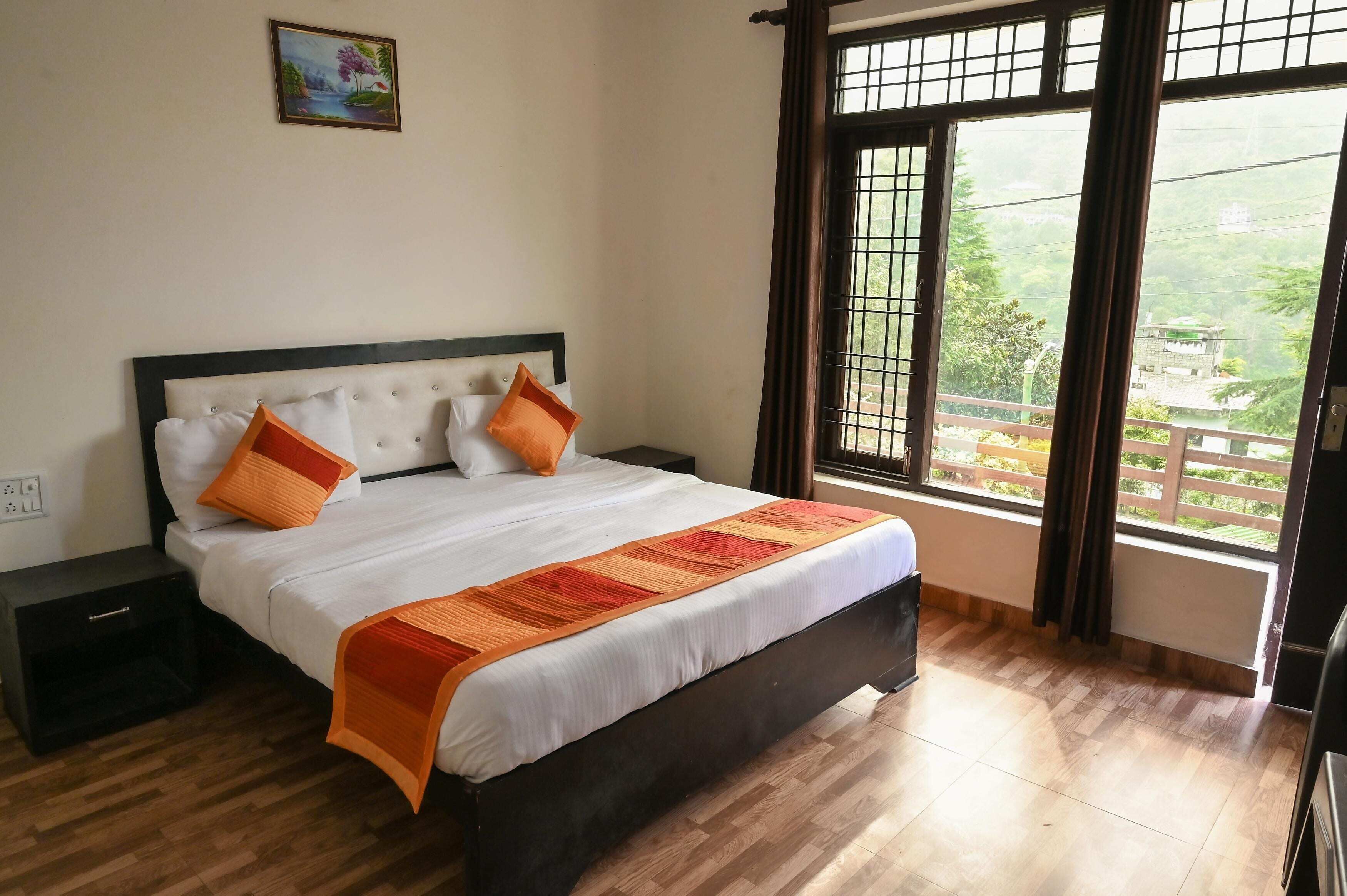 A neatly made bed with a white and orange bedspread, a headboard, and two nightstands.