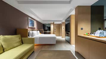 Una habitación de hotel moderna con cama, sofá, escritorio y televisor.
