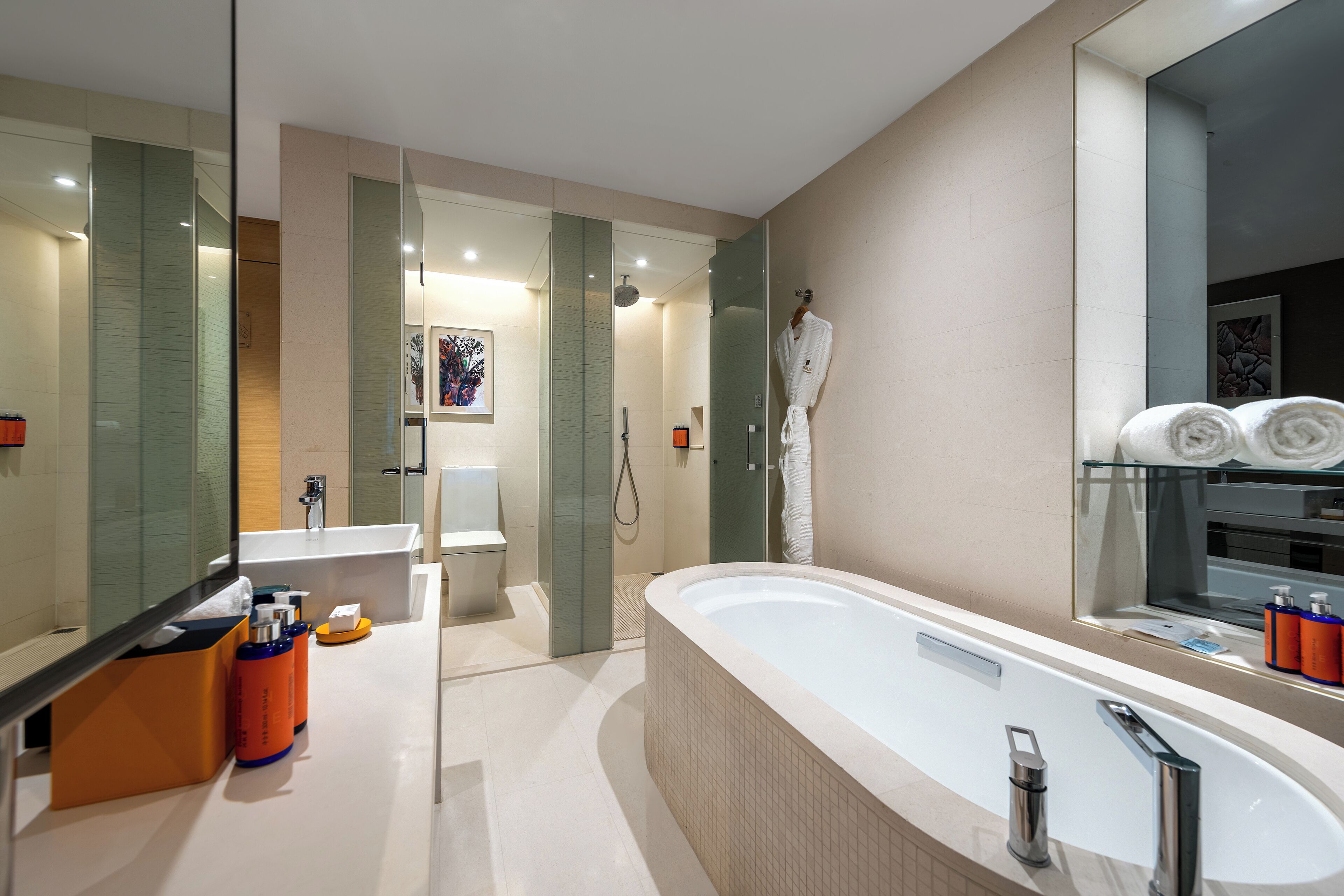 A modern bathroom with a large bathtub, a glass shower enclosure, and a vanity with a mirror.