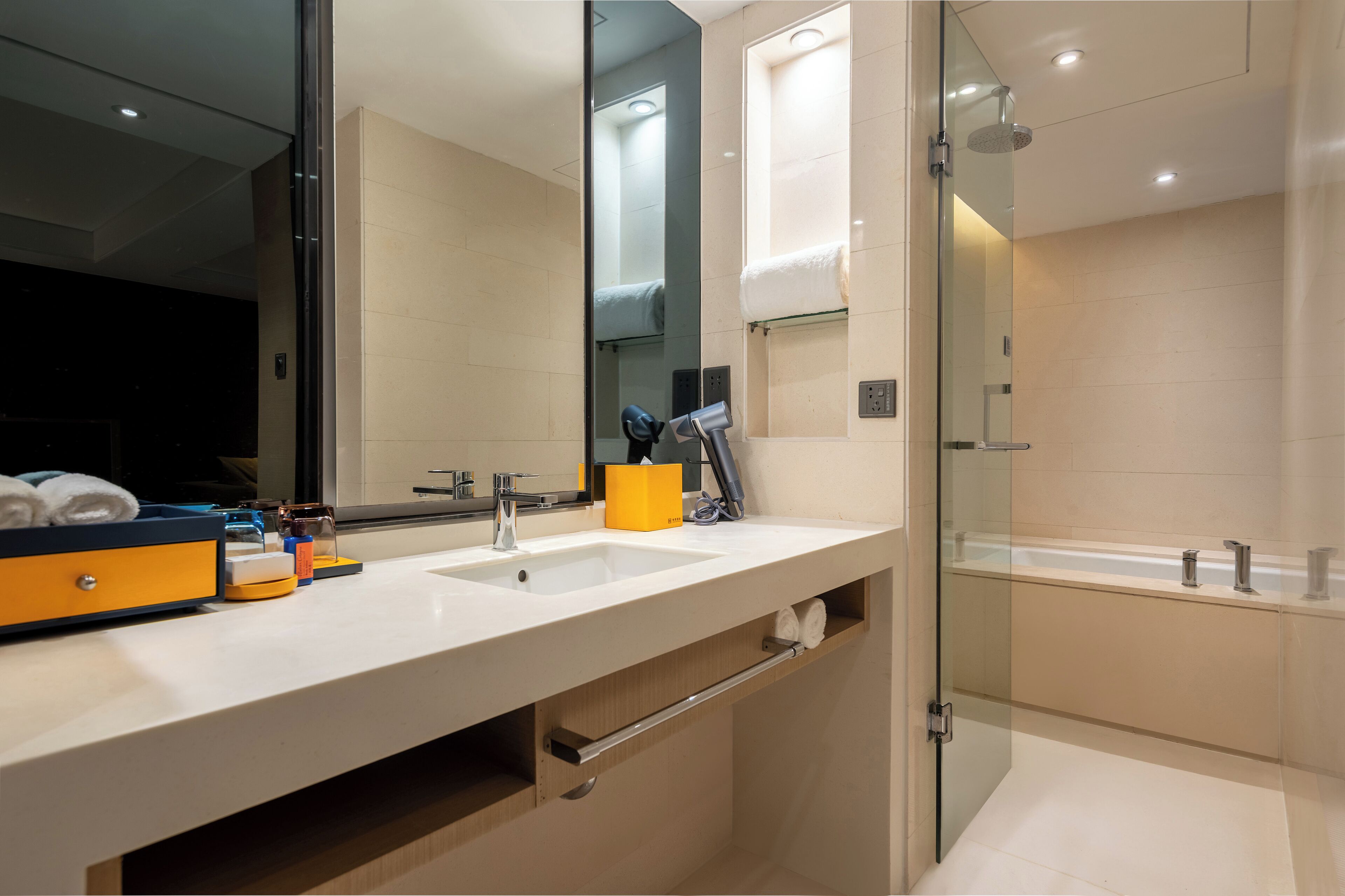 A modern bathroom with a dual sink vanity, a glass shower enclosure, and a large mirror.