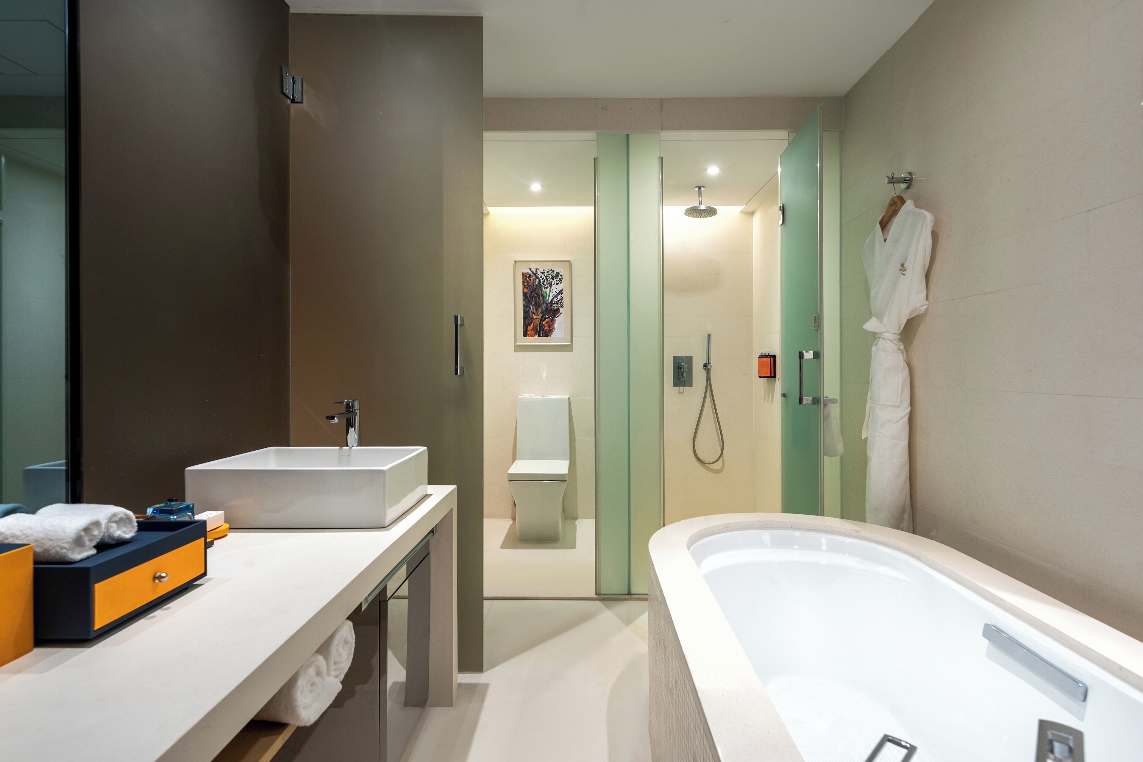 A modern bathroom with a large bathtub, a sink, and a glass shower enclosure.