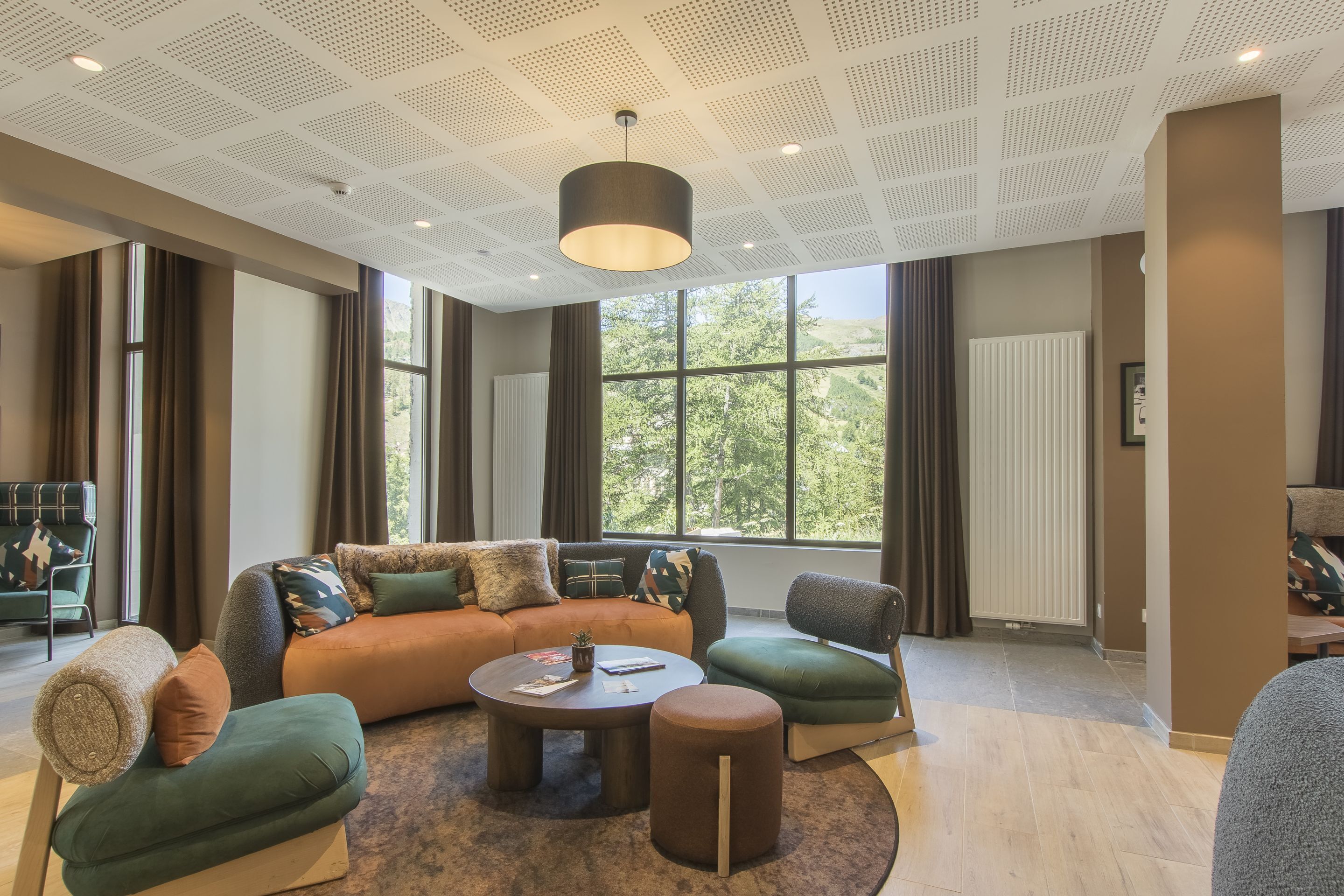 Una sala de estar moderna con un sofá modular, una mesa de centro y un otoman redondo.