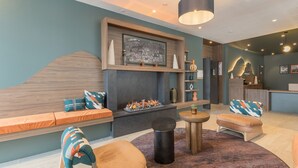 Ein moderner Lounge-Bereich mit Kamin, Sitzgelegenheiten und einer Rezeption.