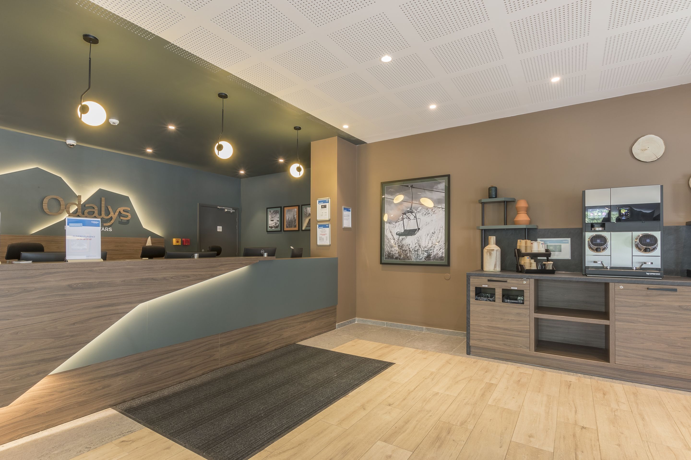 A reception area with a modern design, including a reception desk, framed artwork, and a clock on the wall.