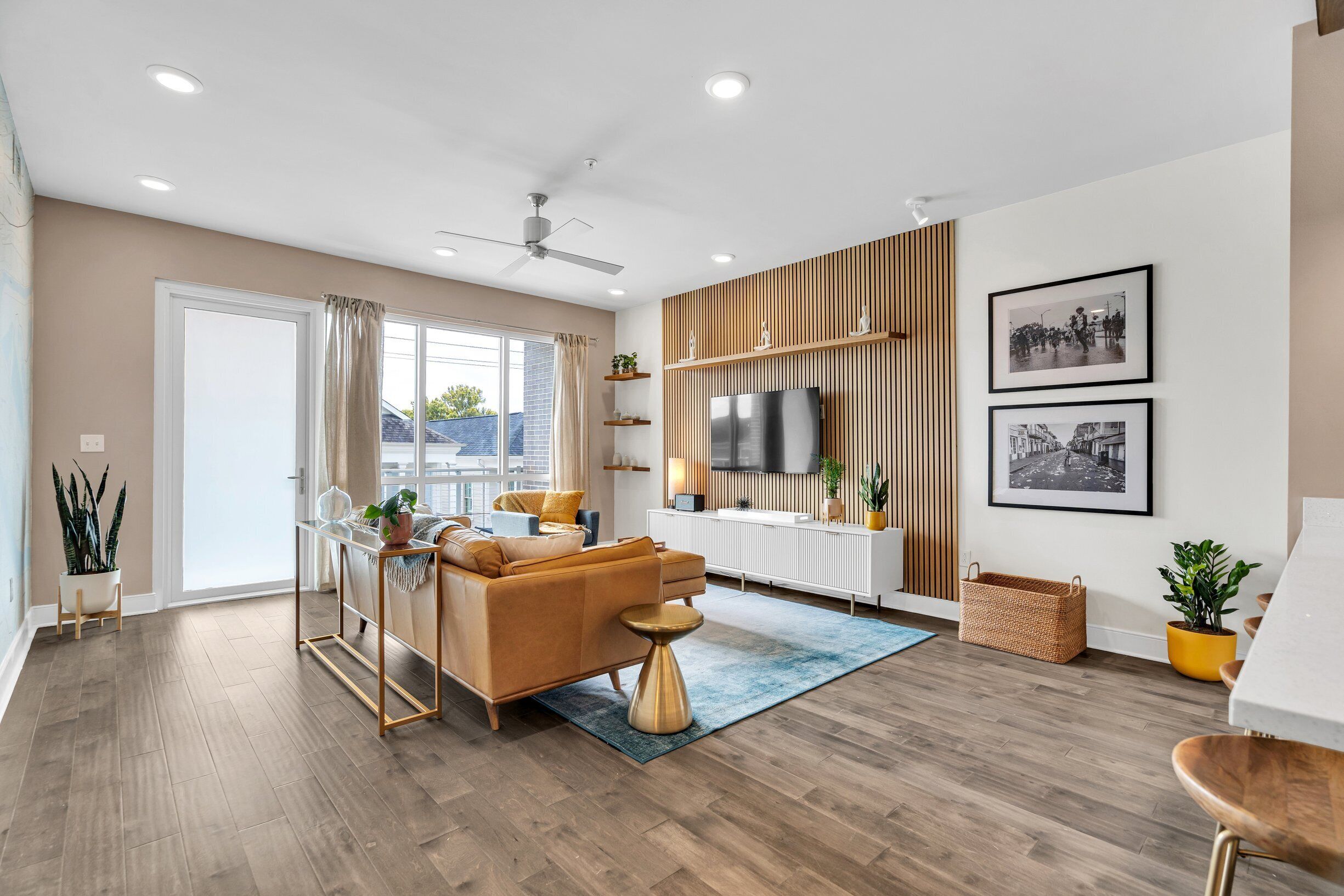 A modern living room with a sofa, coffee table, and a TV mounted on the wall.