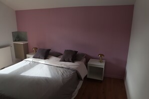 Relax in a stylish bedroom with a large bed, bedside tables, and a shelf unit.