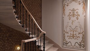 A spiral staircase with a brick wall and a decorative panel with a floral design. - Casa Foscolo Hotel, Istanbul, a Member of Design Hotels (Istanbul)