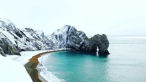 A snow-covered beach with clear turquoise water and rocky cliffs. - Lodge/ Kingbed/ Privg/ Petsok/ Freep/ Wifi (Dorchester)