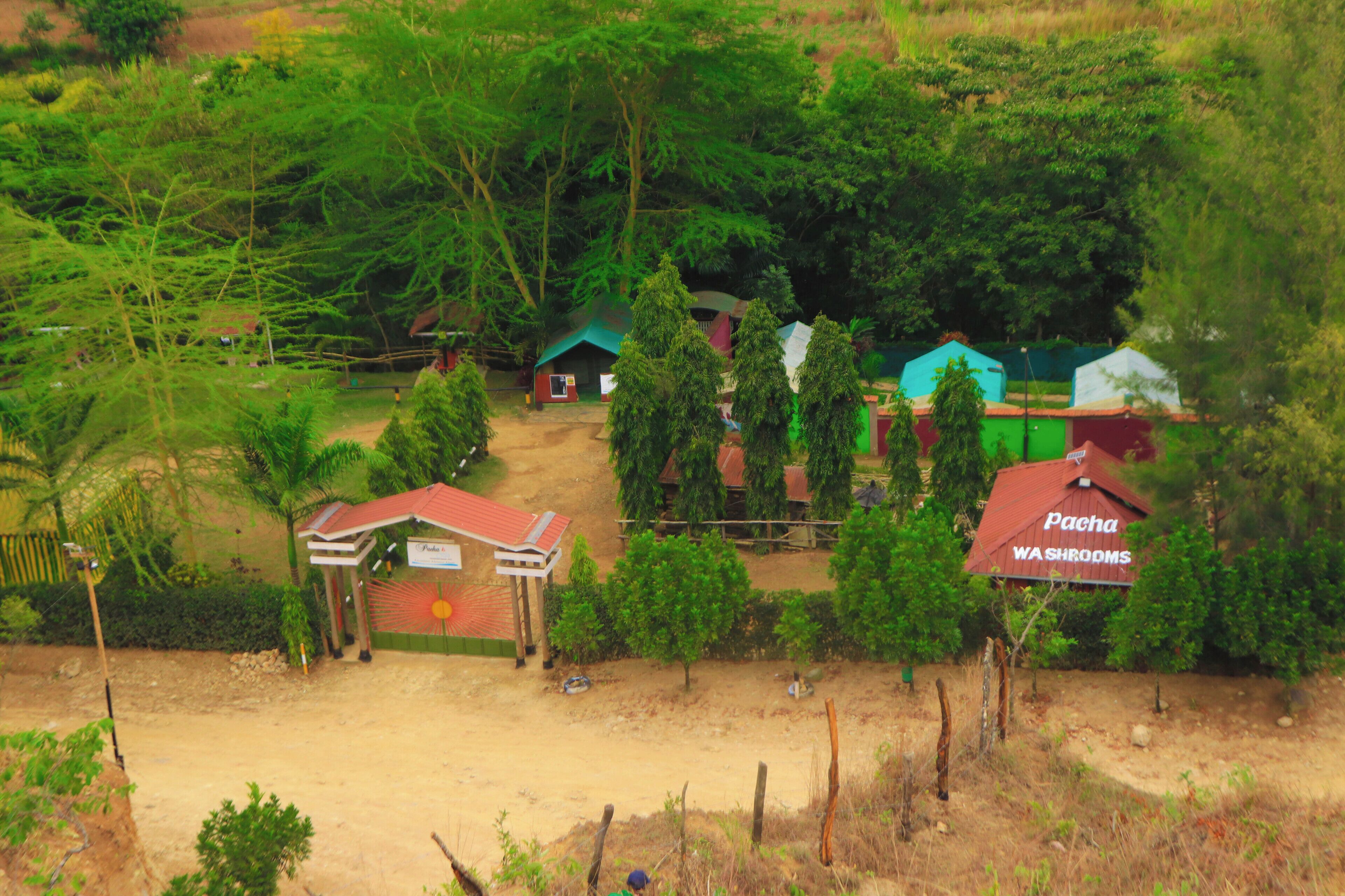 A rural area with several small buildings, including a structure labeled "Pacha Washrooms."