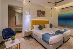 A hotel room with a large bed, a small desk, a chair, and a large window. - World Inn (Visakhapatnam)