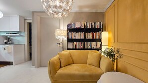 Un saló modern amb un sofà, una biblioteca, una zona de menjador i una cuina.