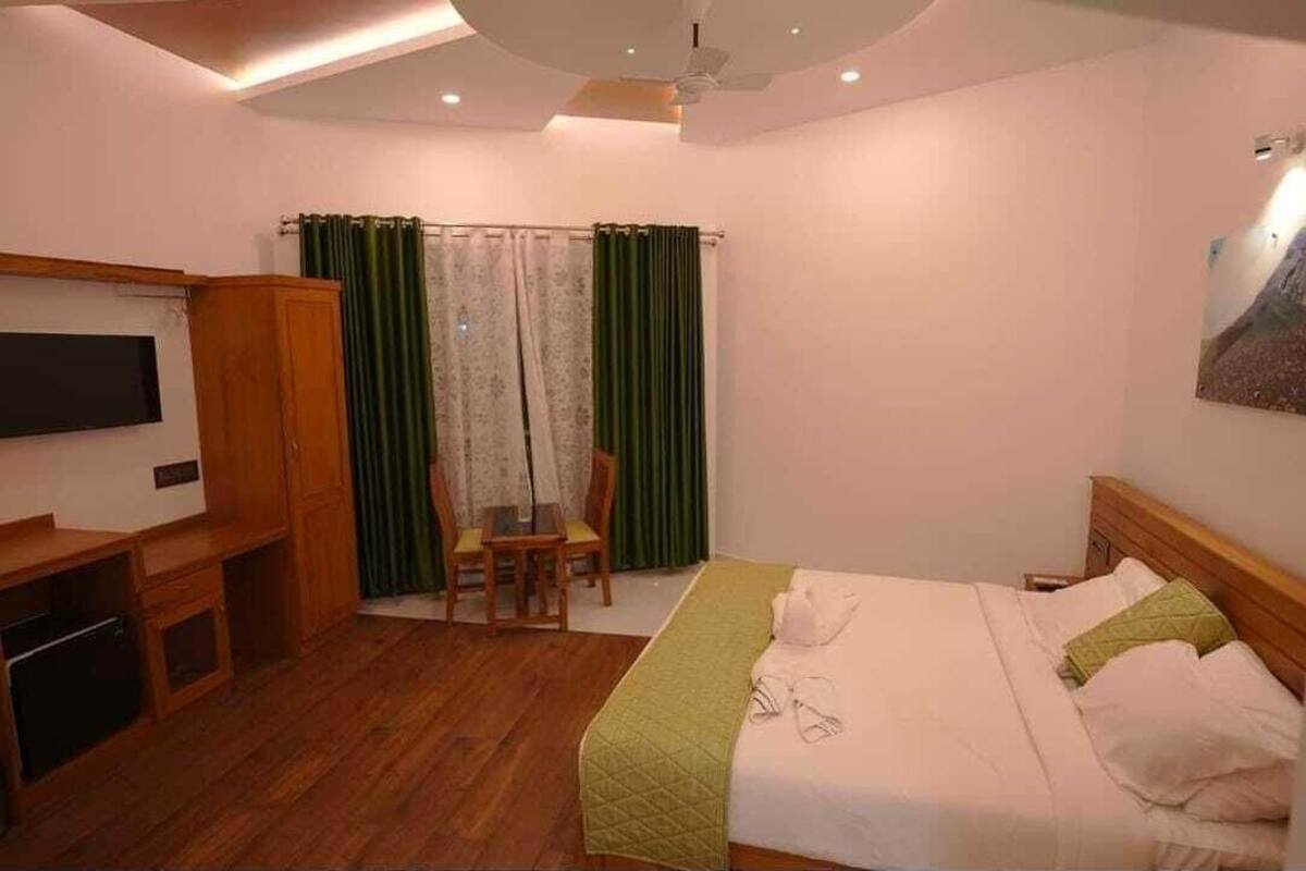 Une chambre à coucher avec un lit, une télévision, un bureau et une chaise.