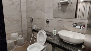 Un bagno con il water, un lavandino e uno specchio.