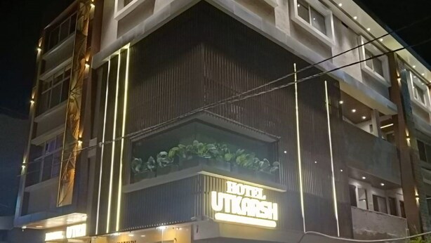 Un edificio a più piani con un cartello ben visibile per l'Hotel Utkarsh.