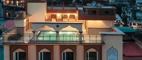 A multi-story building with a balcony and a large window.