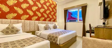 Una habitación de hotel con dos camas, televisión y ventana con cortinas.