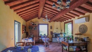 A rustic dining area with wooden beams, a tiled floor, and a table set for four.