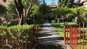 A pathway lined with red railings, surrounded by lush greenery and trees.