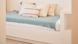 Ein Schlafzimmer mit einem Bett, einer Hängeleuchte und einer Wandlampe.