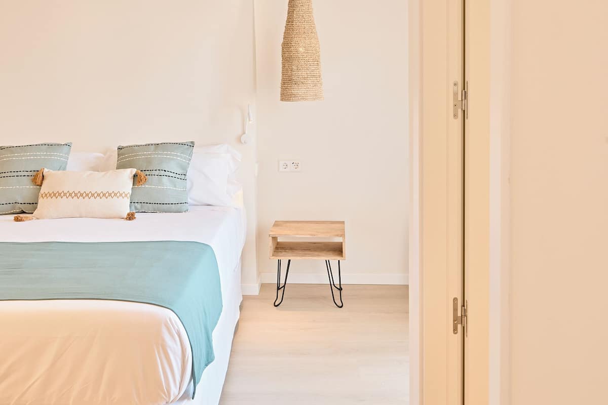 Ein Schlafzimmer mit Bett, Nachttisch und einer Pendelleuchte.